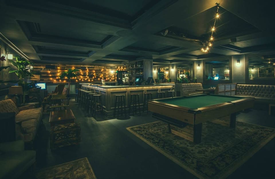 Odd mismatched vintage furniture and pool table inside Better Days bar