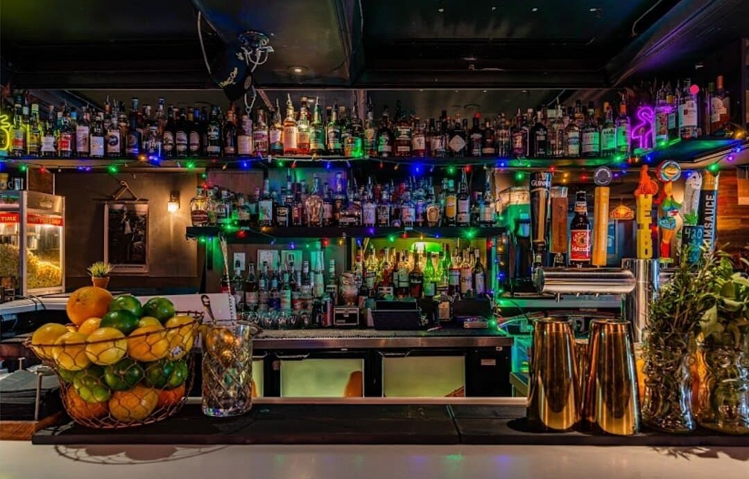 Better Days bar counter lined with bottles and colorful lights