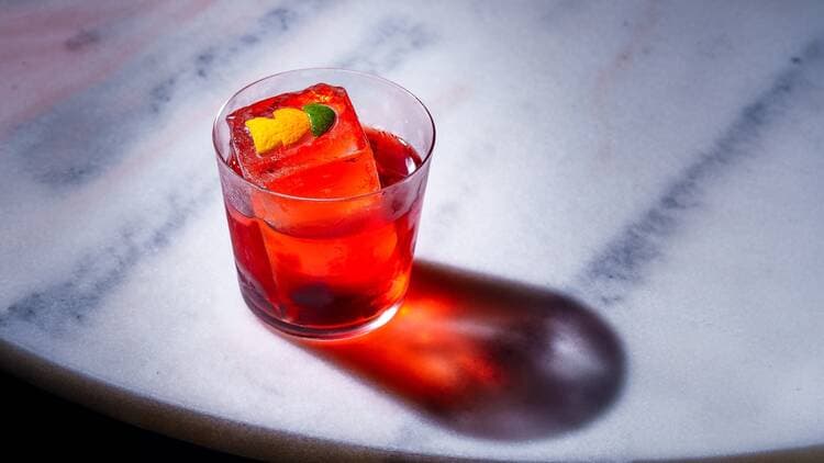 A red cocktail on marble at Better Days Miami