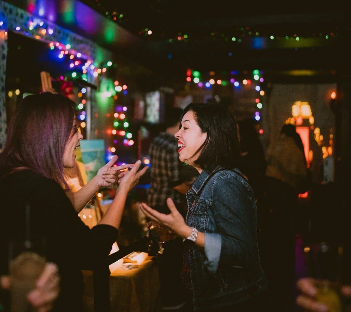 Guests laughing under string lights at Better Days